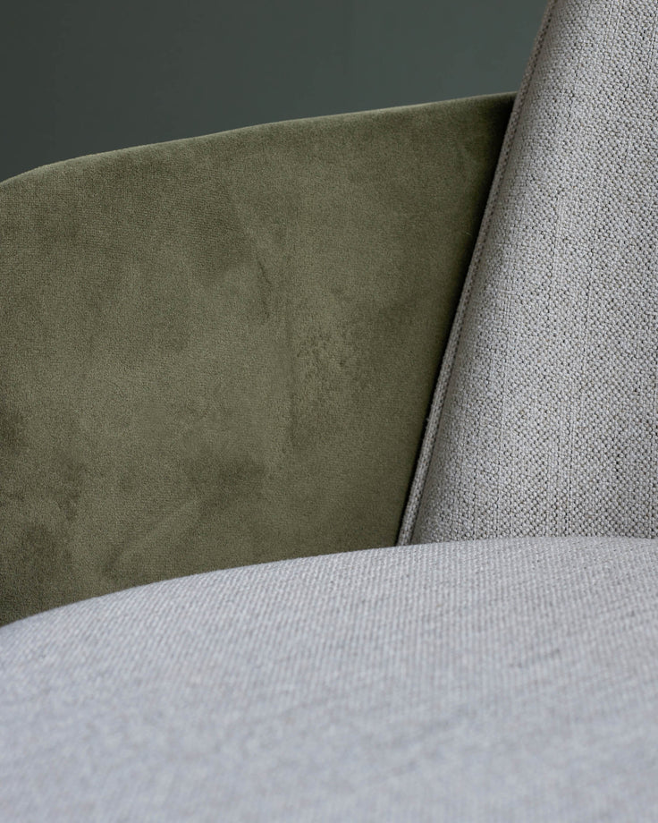 Close-up of a sofa with olive green and light grey textured fabrics. Modern furniture detail.