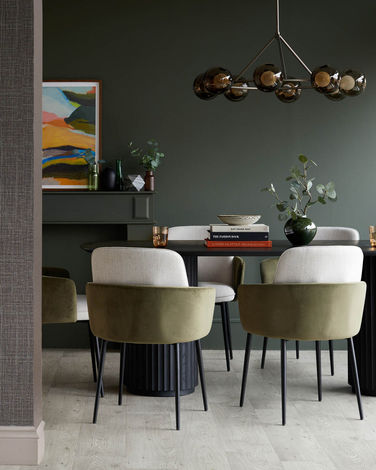 Dining room featuring a dark wood table, modern chairs with olive green and neutral fabric, and a stylish orb chandelier.