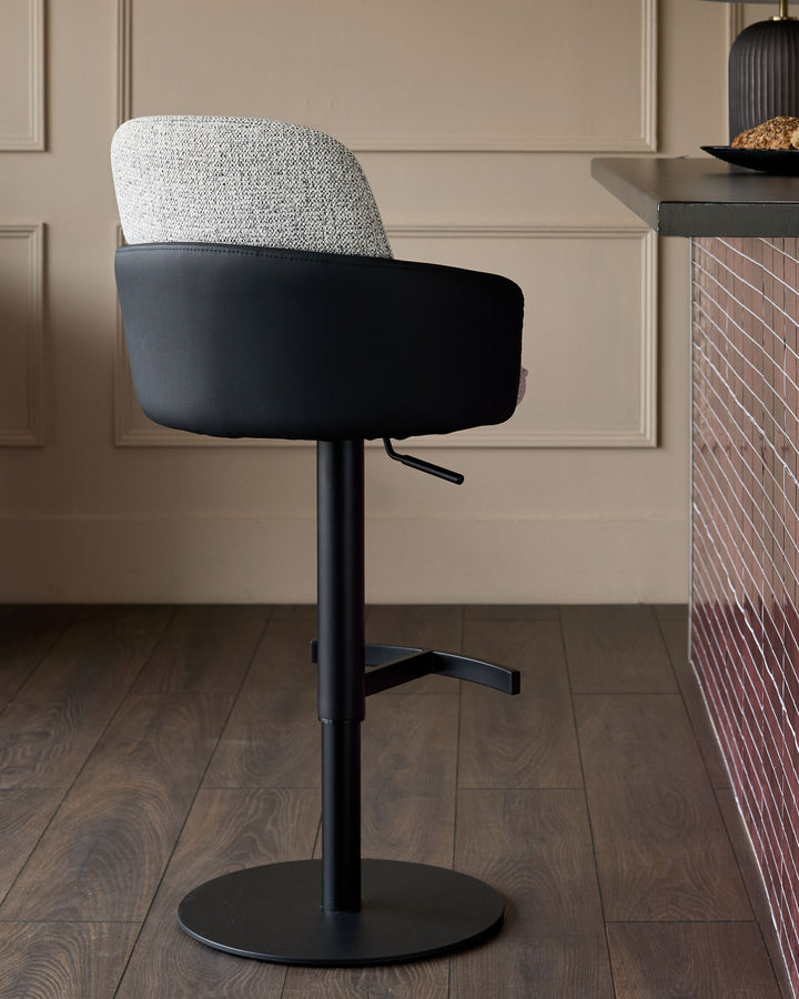 Wren gas lift bar stool with grey fabric back and black faux leather seat, adjustable height, black metal base.
