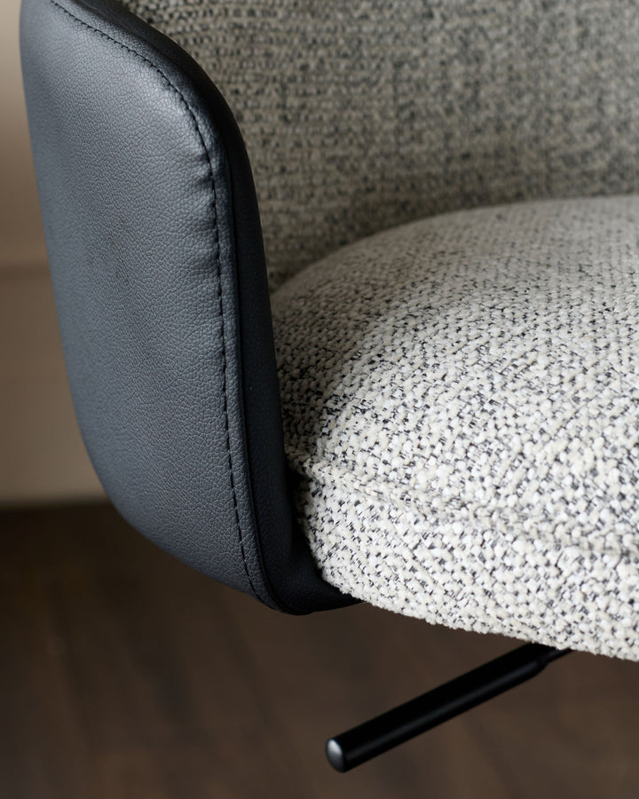Wren gas lift bar stool with grey fabric seat and black faux leather backrest, side view detail.