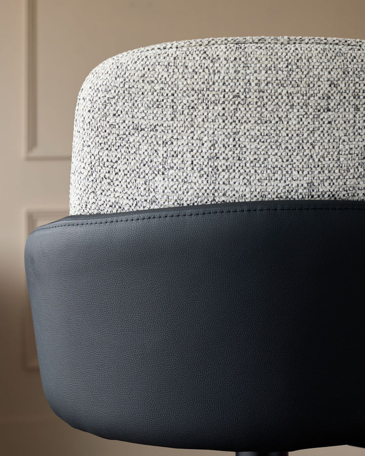 Wren gas lift bar stool with grey textured fabric seat and black faux leather base, side angle view.