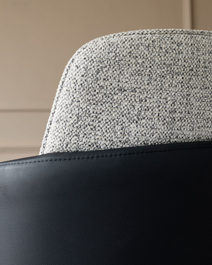 Wren bar stool close-up showing grey fabric seat and black faux leather base detail.