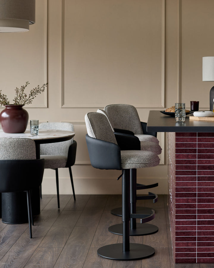 Wren gas lift bar stool in grey fabric and black faux leather, shown in modern kitchen setting.
