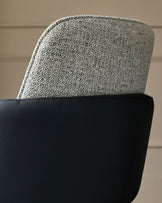 Wren dining chair showing grey fabric backrest and black faux leather seat base in close-up detail.