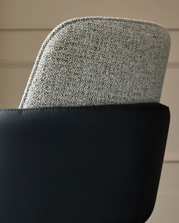 Wren dining chair showing grey fabric backrest and black faux leather seat base in close-up detail.