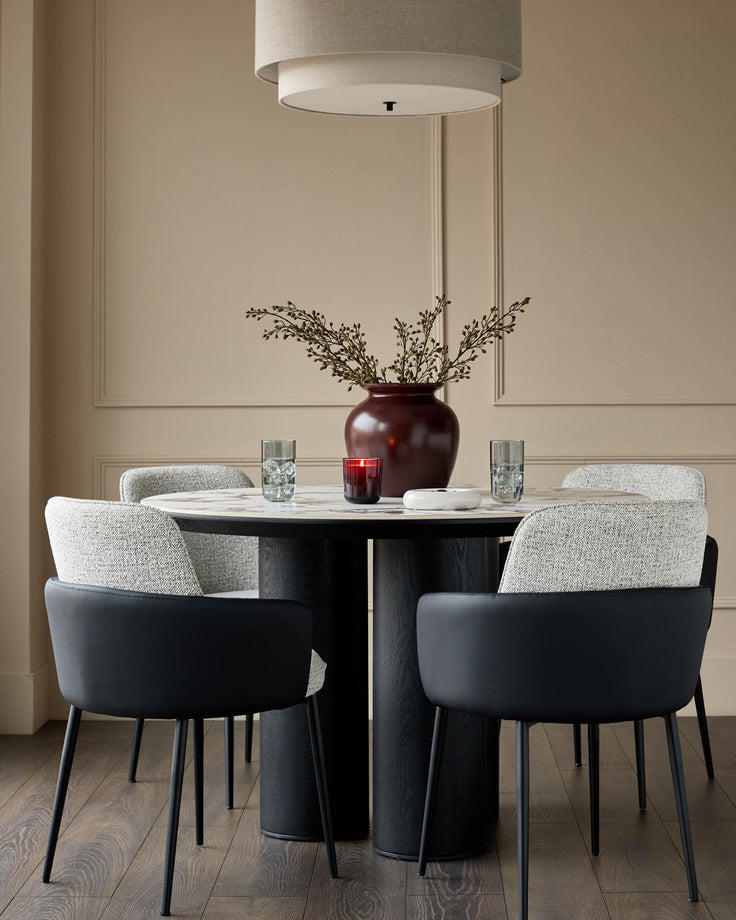 Wren dining chair in grey fabric and black faux leather, shown in a styled dining room setting with round table.