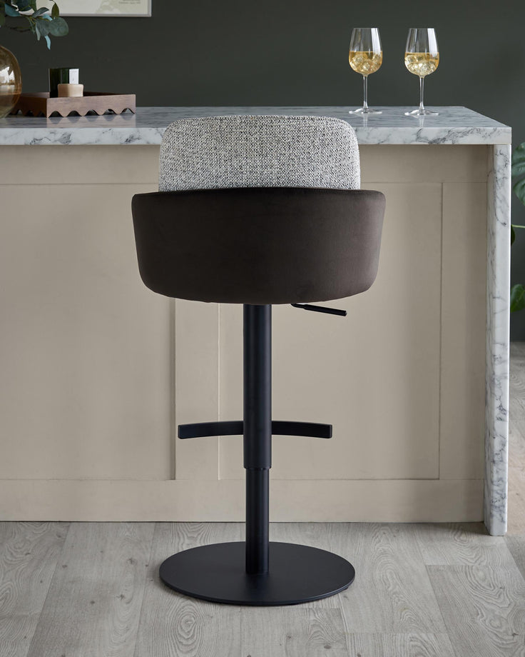 Stylish bar stool with a fabric seat and a black metal base, perfect for adding a touch of modern elegance to your kitchen.