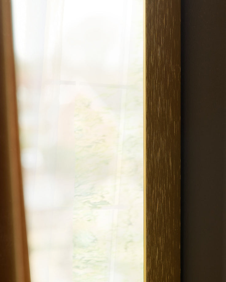 Gold-framed arch wall mirror with textured wood-grain finish and reflective glass surface.
