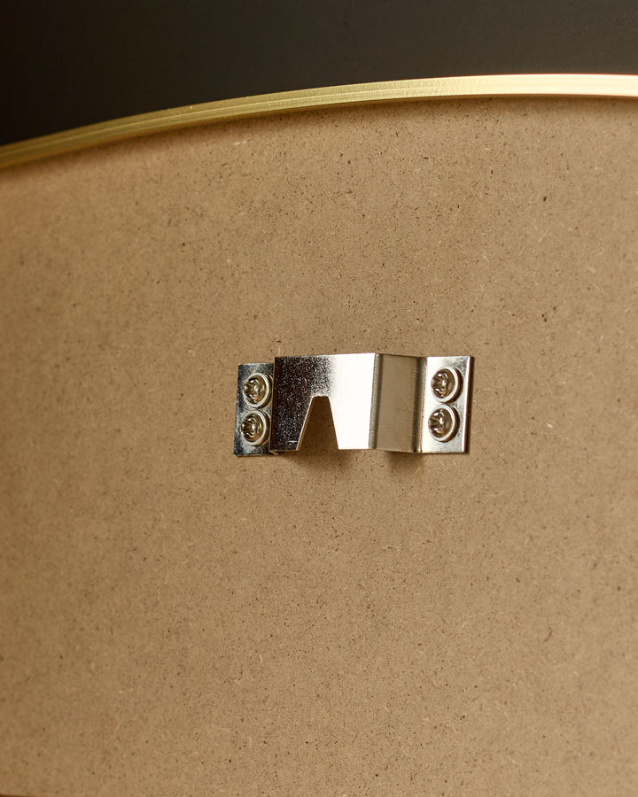 Gold arch wall mirror with polished metal handle and cork backing, close-up detail view.