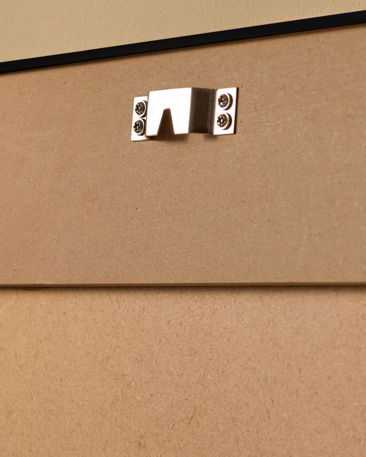 Silver metal handle with screw fasteners mounted on cork-textured beige surface.