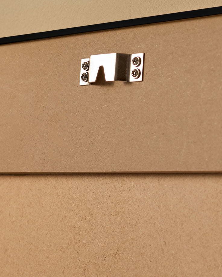 Silver metal handle with screw fasteners mounted on cork-textured beige surface.