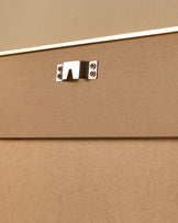 Close-up of polished chrome handle on tan upholstered furniture panel with white trim detail.