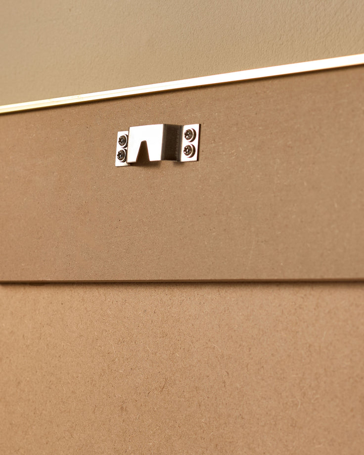 Close-up of polished chrome handle on tan upholstered furniture panel with white trim detail.