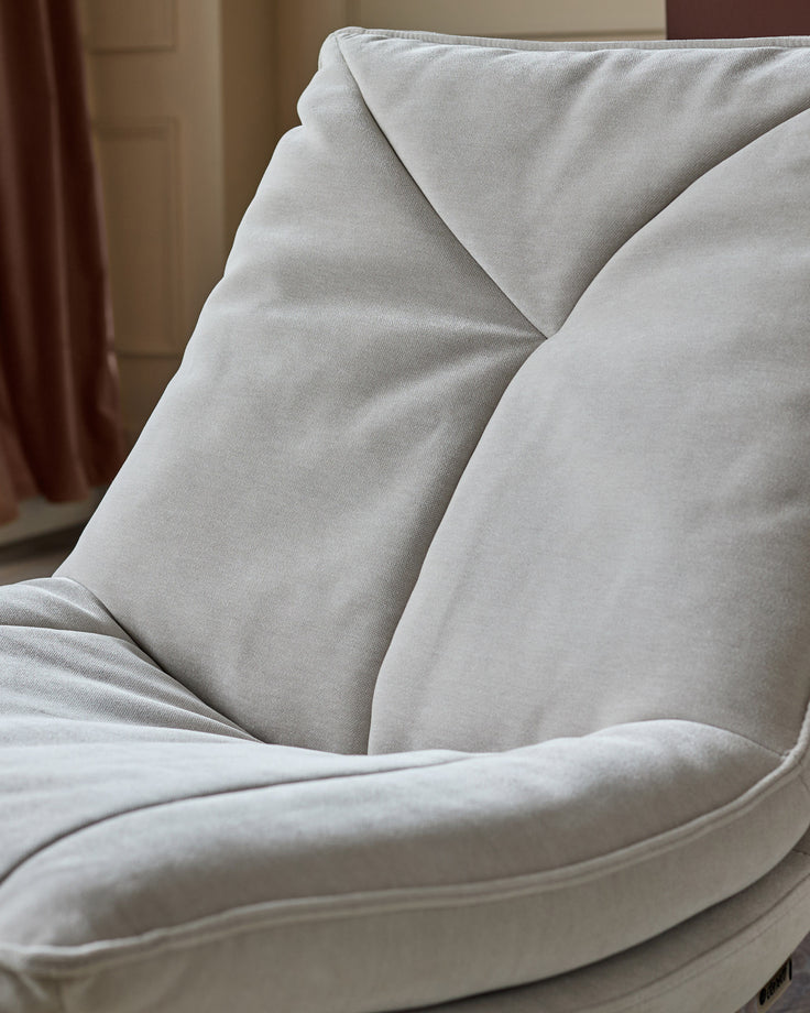 Zia Swivel Chair in natural grey fabric, close-up detail of plush seat cushioning and curved armrest.