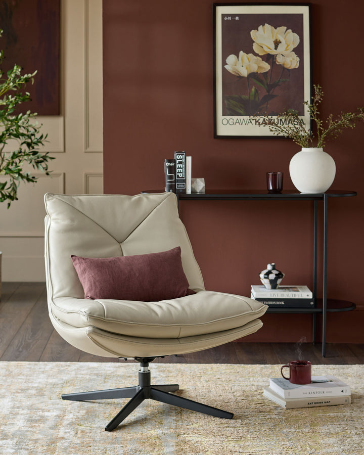 Cream leather swivel chair with curved back and padded seat on black metal base, styled in modern living room.