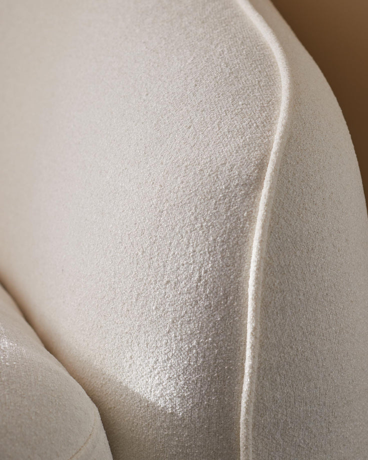 Close-up of a white textured sofa, showcasing the fabric and design details.
