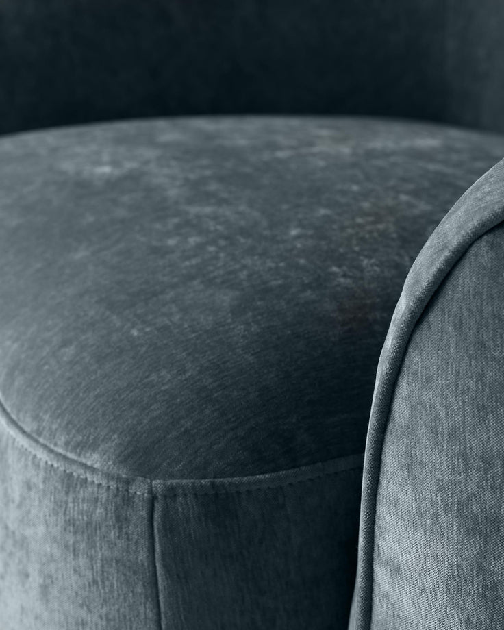 Close-up of a stylish, deep teal armchair with a soft, textured fabric. Perfect for adding a touch of class to any room.