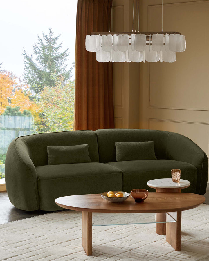A stylish olive-green sofa, wooden coffee table and marble side table create a cosy, modern living space.