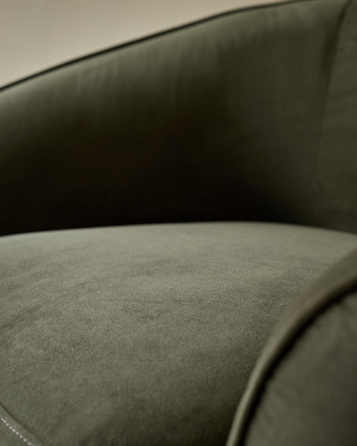 Close-up of a stylish green velvet armchair, showcasing its soft texture and inviting design. Perfect for cosy relaxation.