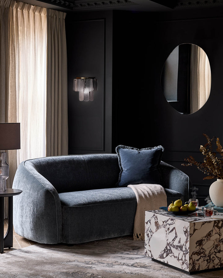 Estelle wall light with frosted glass shades mounted on black wall in modern living room setting.
