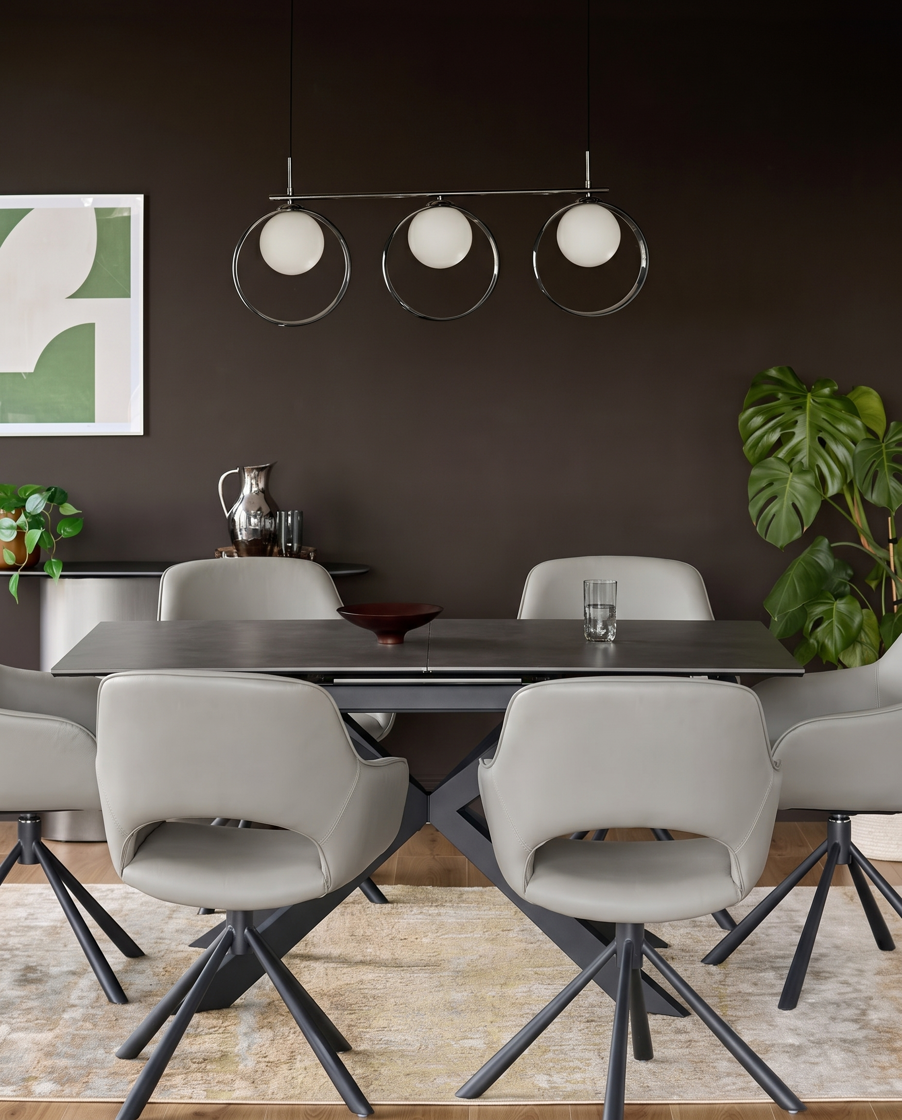 Marlow light grey leather swivel dining armchair with black star base, shown at dining table in contemporary room setting.
