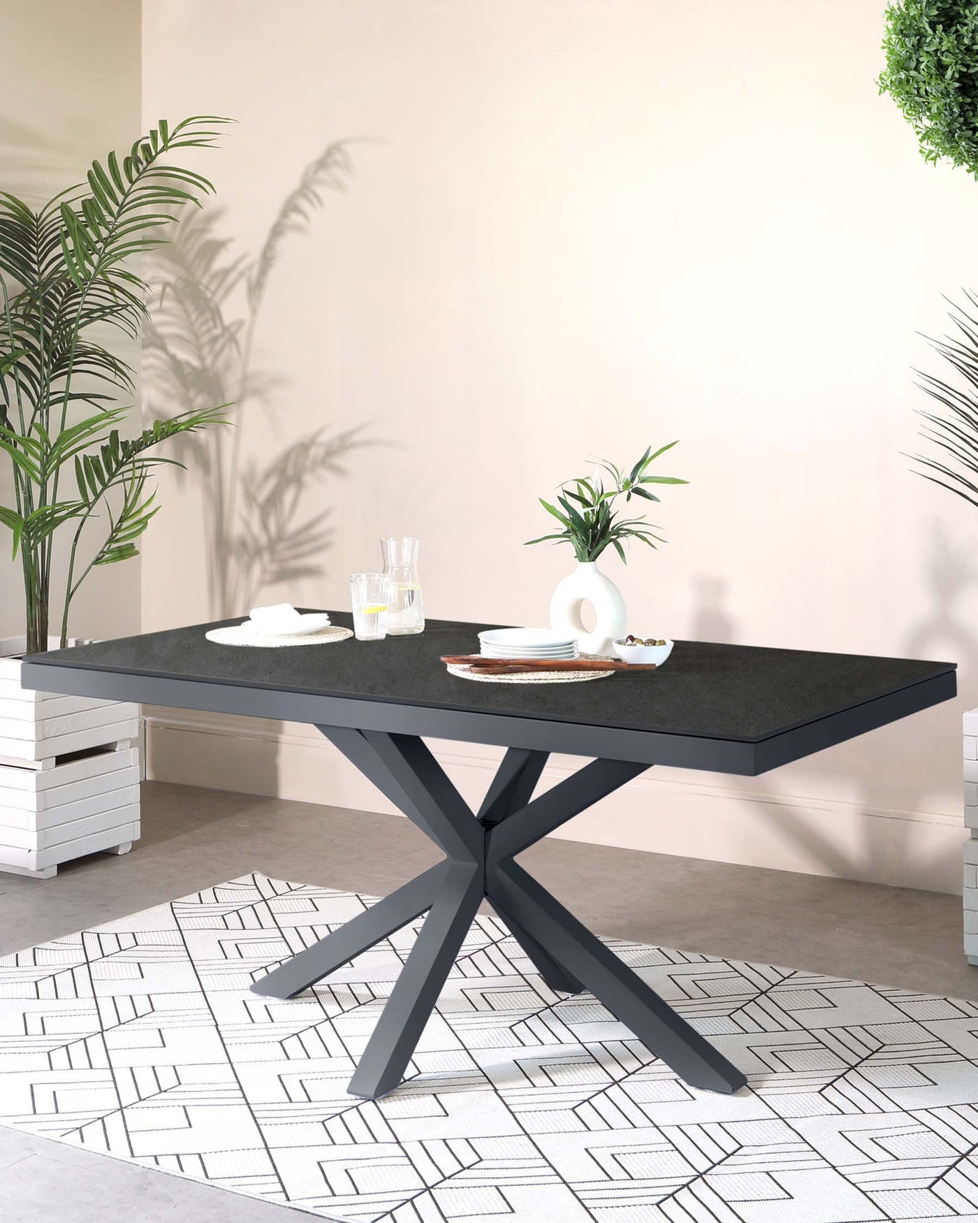 Modern rectangular dining table with a black stone tabletop and a geometric metal base in a dark matte finish.