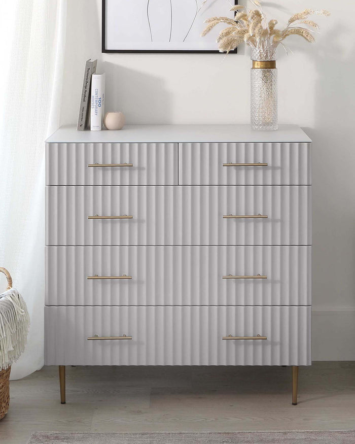 Modern light grey dresser with textured front panels and six drawers featuring sleek brass handles, complemented by tapered brass legs.