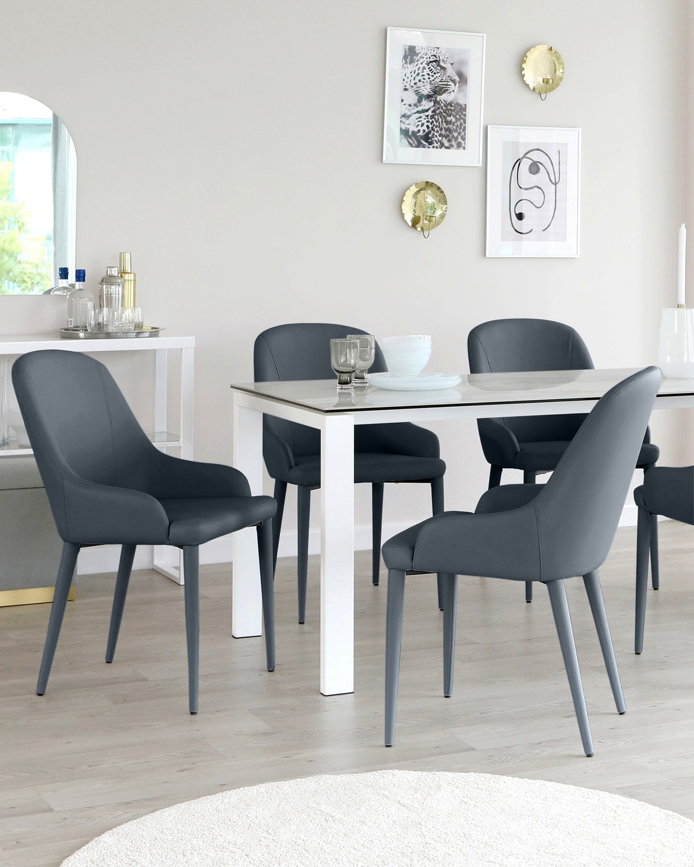 Modern dining set featuring a white rectangular table with a clean, minimal design and four sleek, dark grey upholstered chairs with gently curved backs and angled legs.