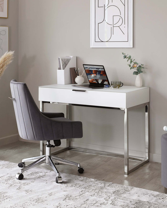 A modern home office setup featuring a sleek, white desk with a glossy finish and silver metal legs, paired with a comfortable grey upholstered office chair that has a high backrest, armrests, and sits on a five-point wheeled chrome base.
