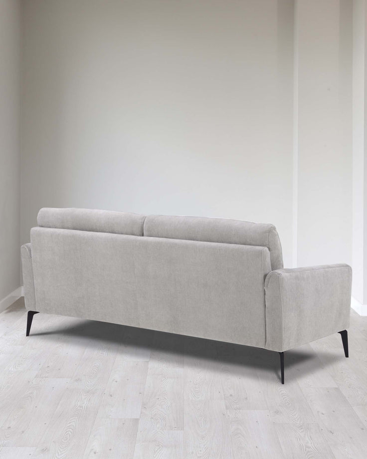 Modern three-seater sofa with a minimalist design featuring light grey upholstery and tapered black wooden legs.