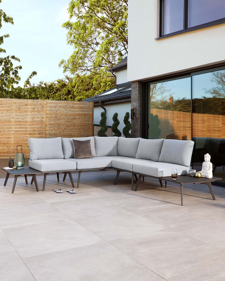 Modern outdoor sectional sofa with light grey cushions on a minimalist dark frame, paired with a matching low rectangular coffee table.