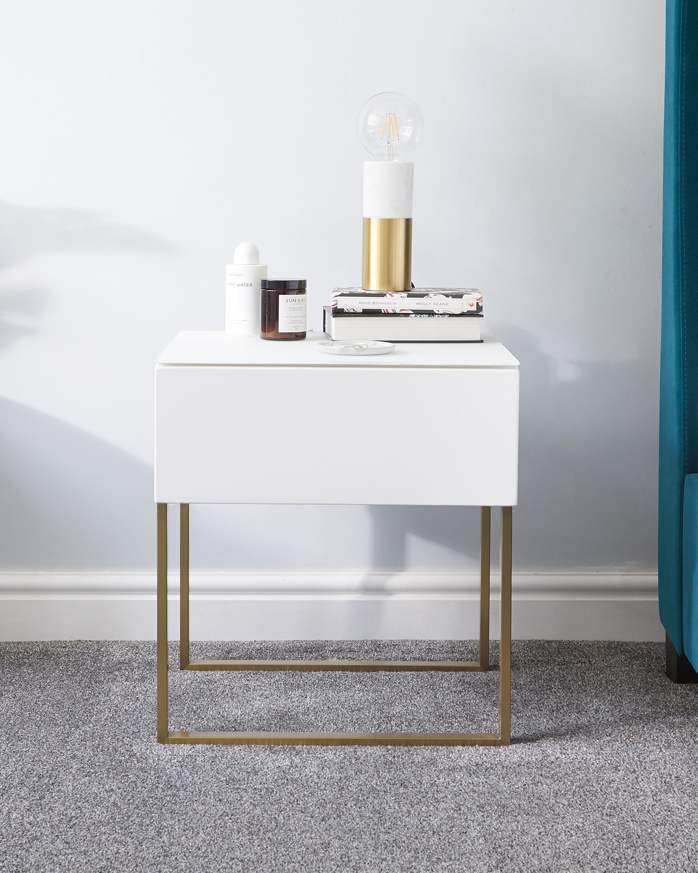 Modern white rectangular side table with a sleek finish and golden metal legs in a minimalist style.