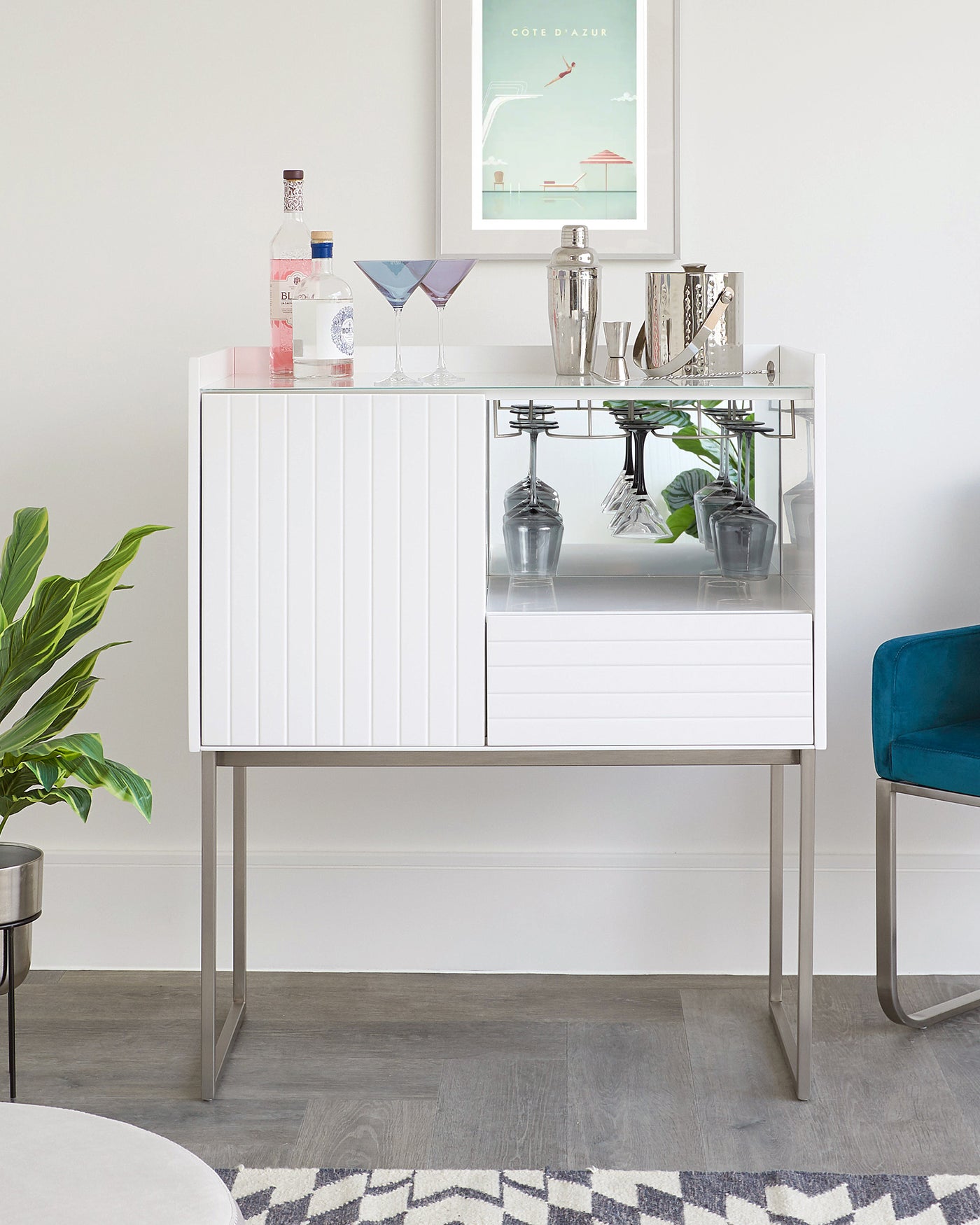 Modern white bar cabinet with sleek lines, featuring a high-gloss finish, ribbed front panel detailing, and a tempered glass shelf. The cabinet is elevated on a minimalistic metal frame base.