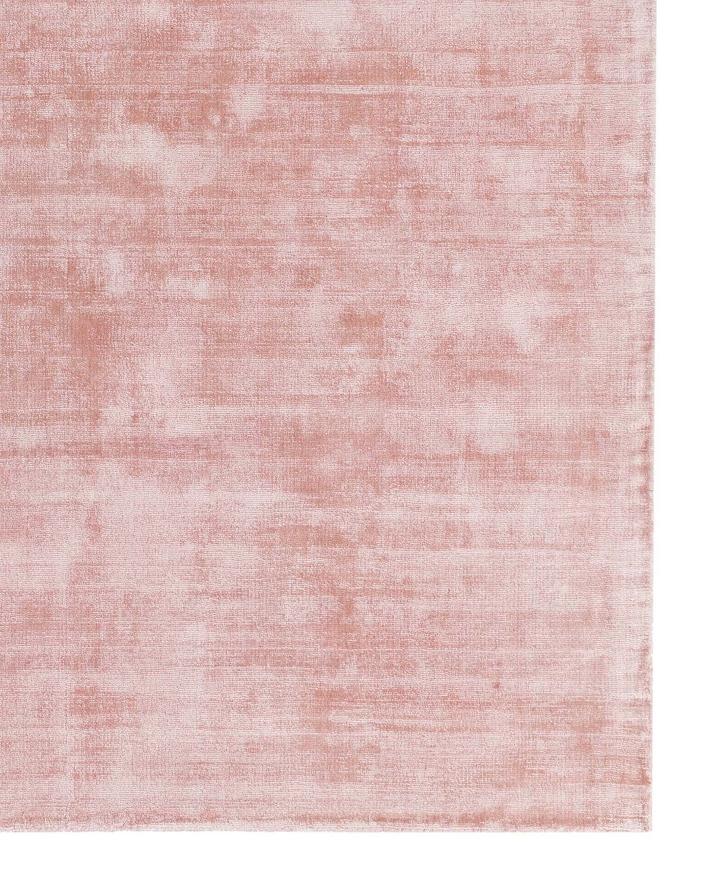 Soft blush pink area rug with a subtle distressed texture effect.