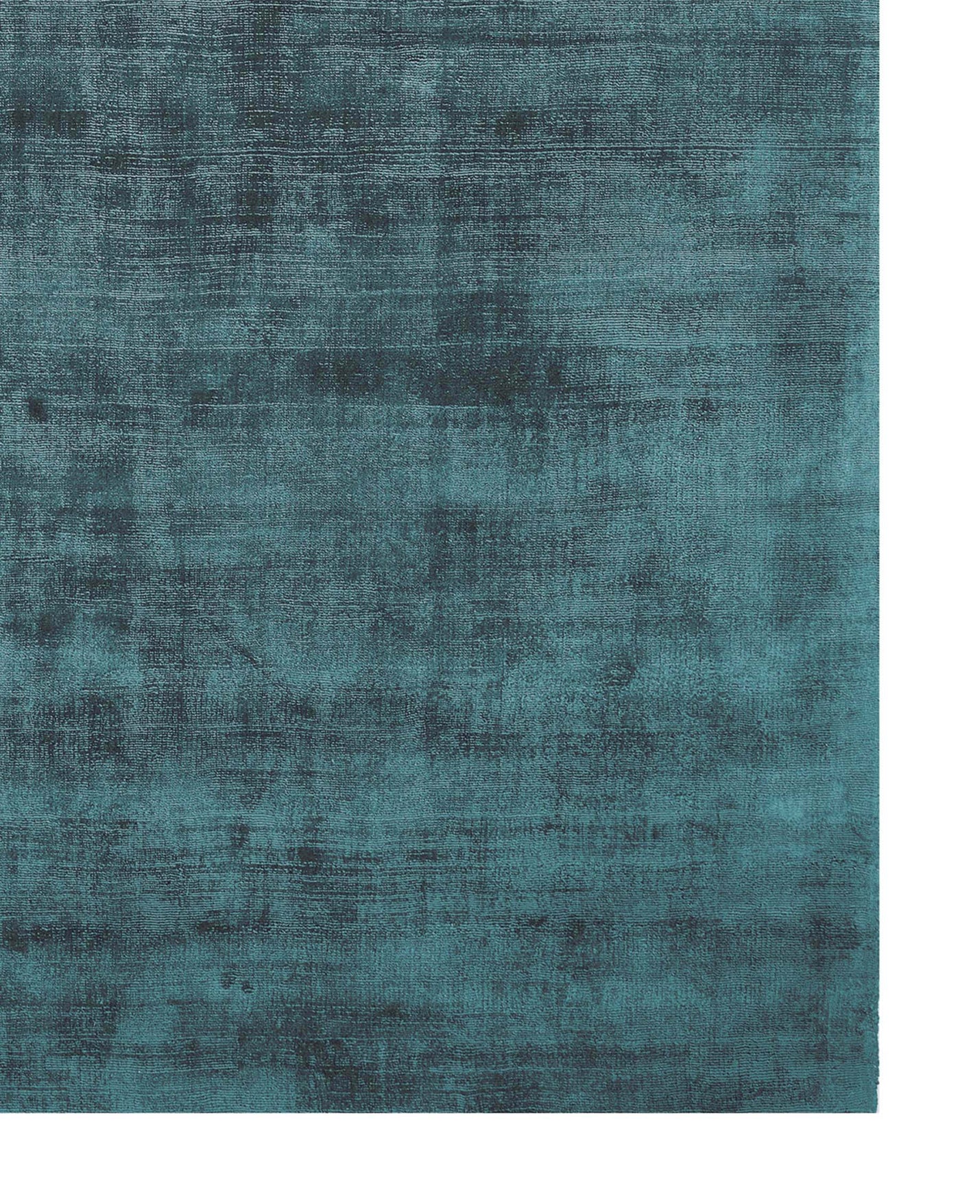 The image displays a textured deep teal area rug with a distressed, vintage look and a subtle sheen, adding both comfort and style to a room's decor.