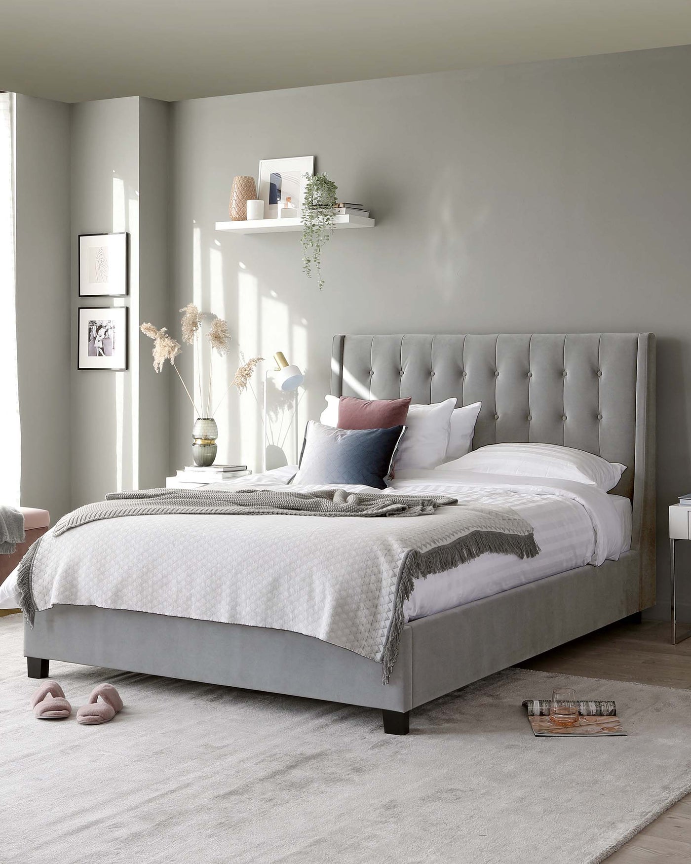 Elegant grey upholstered bed with tufted headboard and a matching bench at the foot of the bed, placed on a grey area rug.