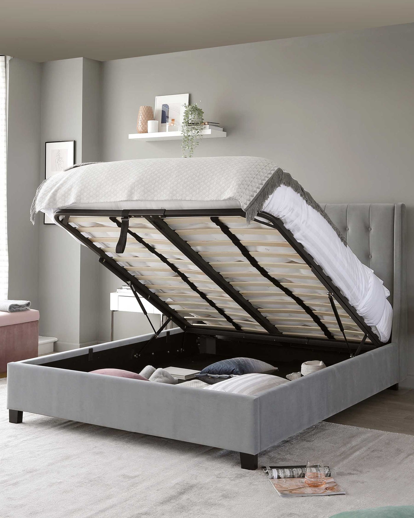 A contemporary grey upholstered storage bed with a button-tufted headboard and an easy-lift hydraulic system revealing ample under-mattress storage.