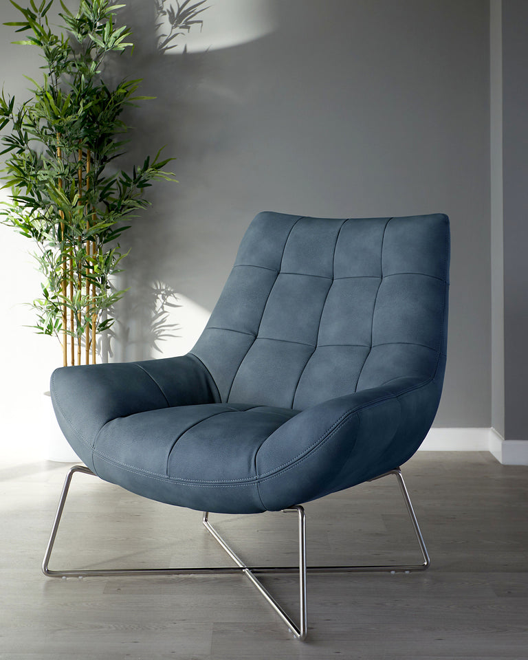 A modern blue upholstered lounge chair with a contoured design and tufted detailing, featuring a sleek chrome cantilever base. The chair is positioned on a light wooden floor next to a tall, slender potted bamboo plant, with a grey wall in the background casting soft shadows.