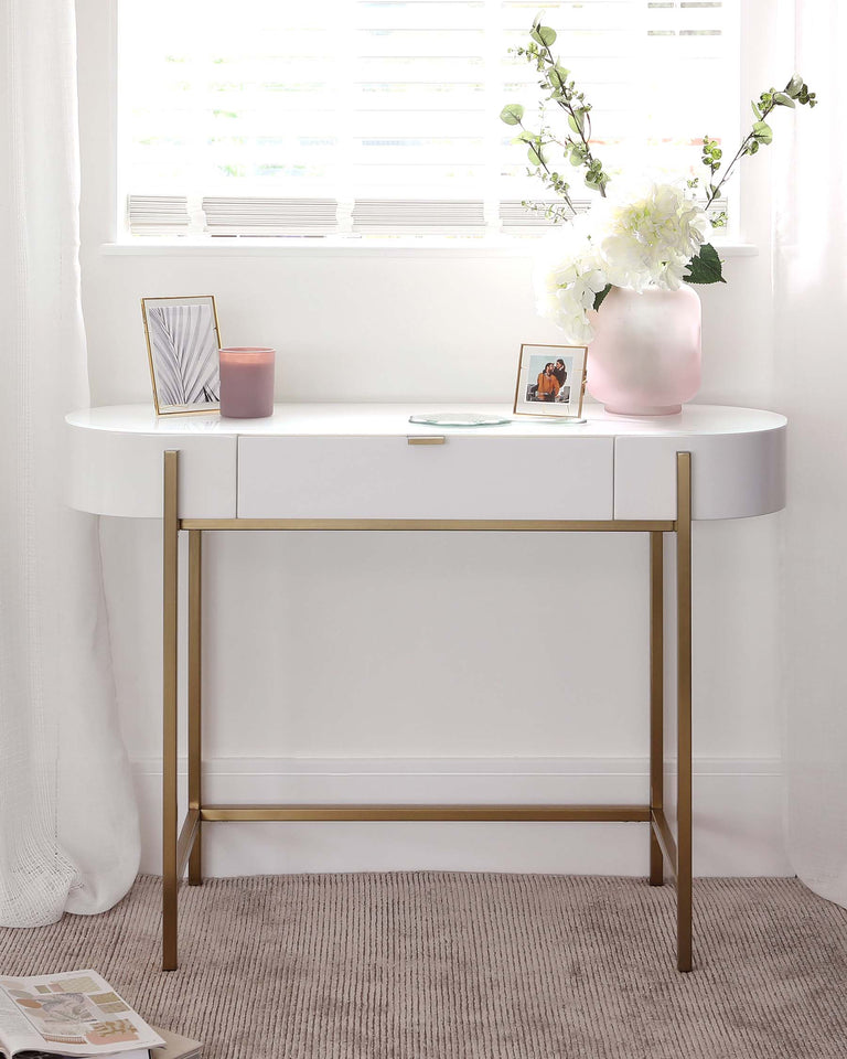 Modern white oval console table with a curved silhouette and a sleek storage drawer featuring a gold-tone handle and slender gold-tone metal legs.
