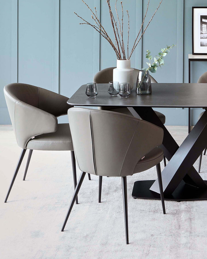 A modern dining set featuring a rectangular dark tabletop with an angular black base, complemented by four sleek taupe upholstered chairs with curvilinear backs and slender metal legs. The set is staged on a soft, light-coloured area rug.