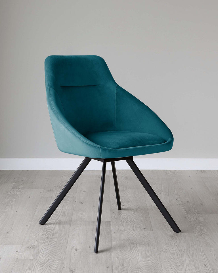 Modern teal upholstered chair with a curved backrest and a minimalist black metal four-legged base, displayed on a light wooden floor against a plain light grey wall.
