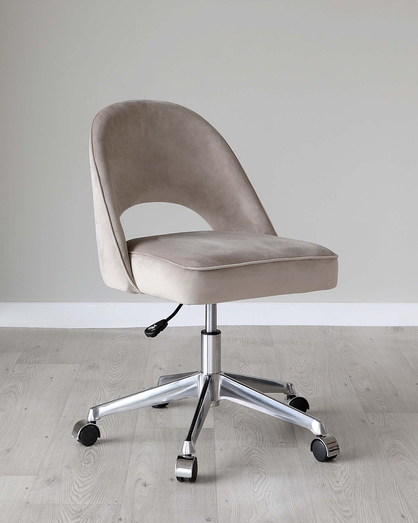 Modern swivel office chair with a plush velvet-like taupe upholstery, curved backrest, and a sleek chrome base with five caster wheels.