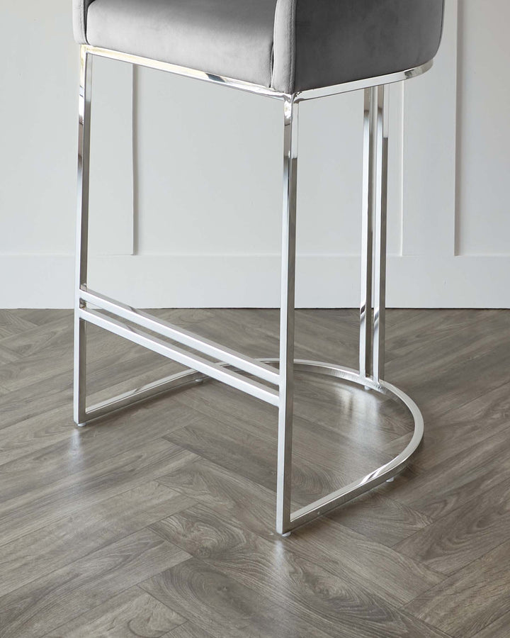 Modern bar stool with a sturdy chrome frame and a plush, grey upholstered seat.