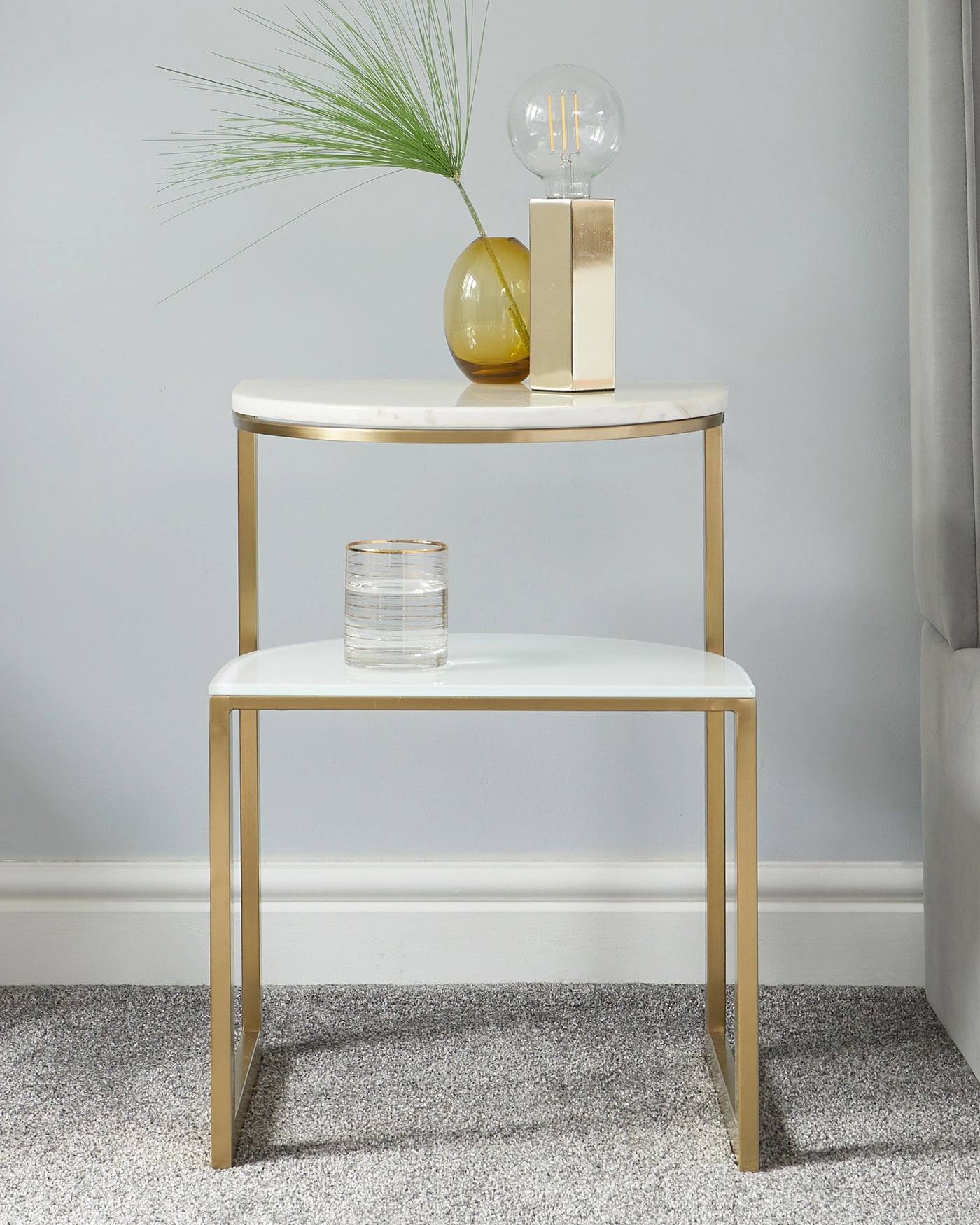 Elegant contemporary two-tier round side table with a white tabletop and gold-finished metal frame, featuring sleek lines and a minimalistic design.