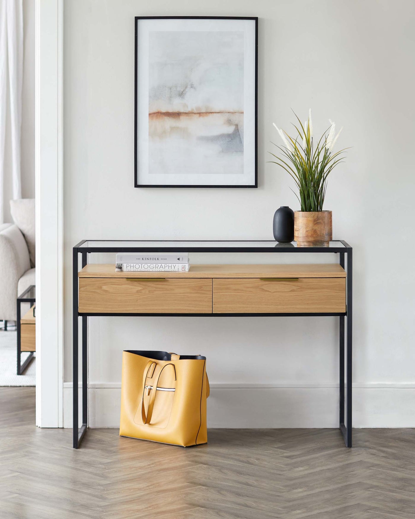 Contemporary console table with a sleek black metal frame and two natural wood-finish drawers.