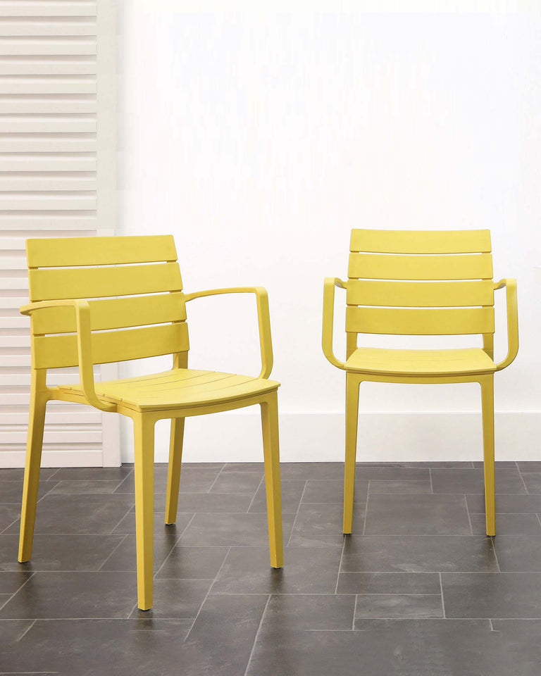 Two modern yellow armchairs with horizontal slat backrests and flat armrests, standing on a grey tiled floor against a neutral background with white blinds on the window.
