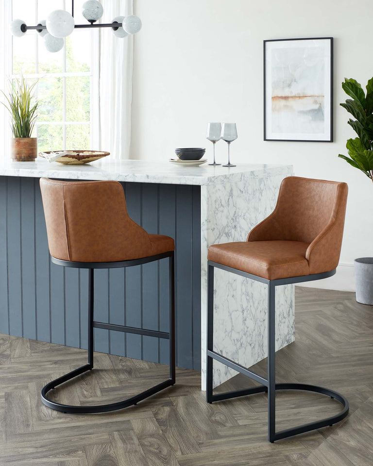 Two contemporary bar stools with tan faux leather upholstery and sleek black metal frames, positioned at a white marble countertop in a modern kitchen setting.