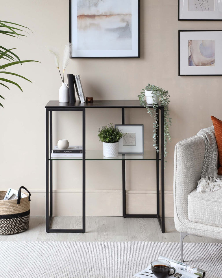 Modern minimalist black metal frame bookshelf with three tiers, featuring a combination of open and closed back shelving. Accessories include decorative vases, plant pots, framed artwork, and books, complementing a stylish contemporary living space.