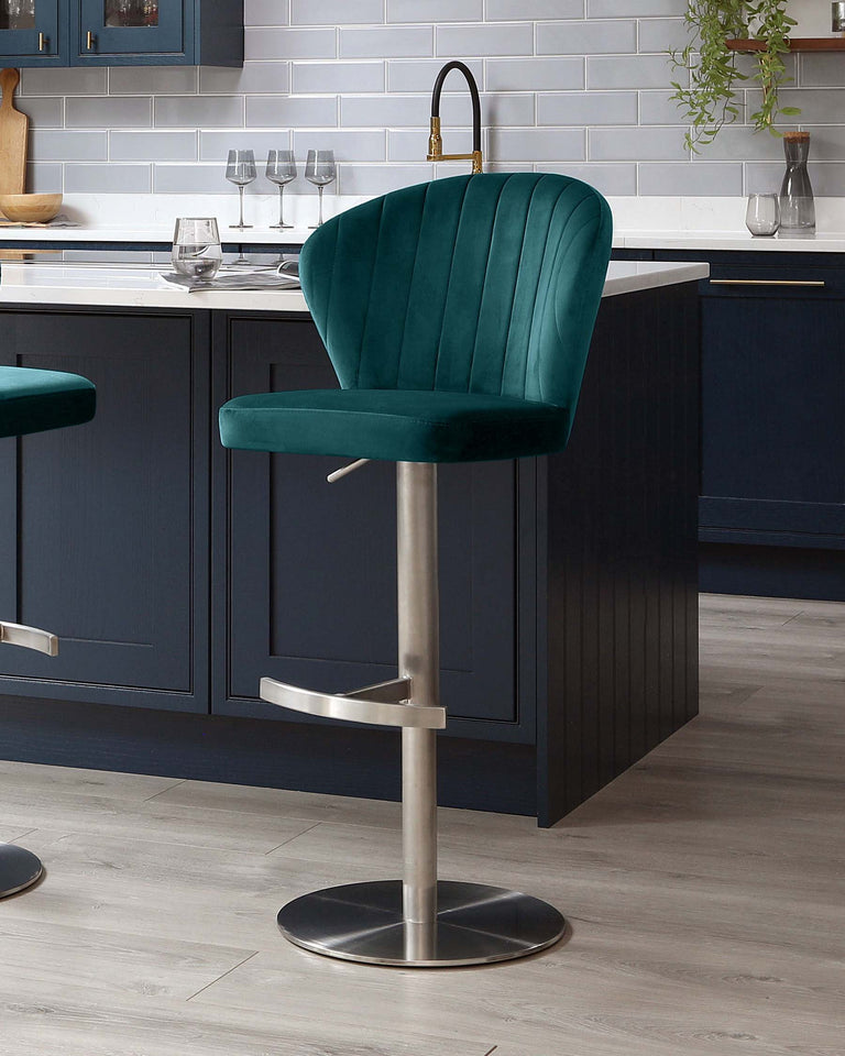Elegant emerald green velvet bar stool with a curved backrest, horizontal channel tufting, and a sleek chrome-finished pedestal base with a footrest.