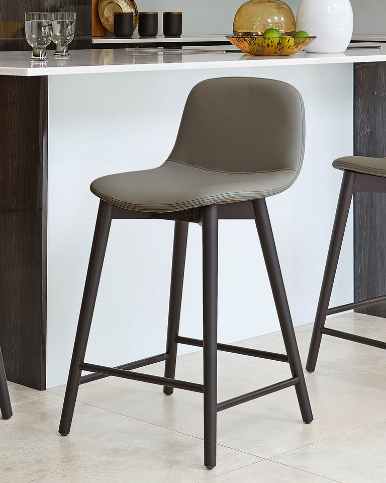 Modern grey upholstered bar stool with a curved seat and backrest, featuring sleek black metal legs with a geometric triangular support structure.